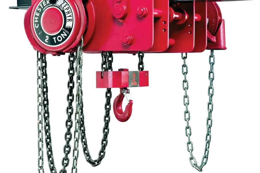 Red manual chain hoist with a 2-ton capacity, mounted on a steel beam, featuring chains and a hook for lifting heavy loads.