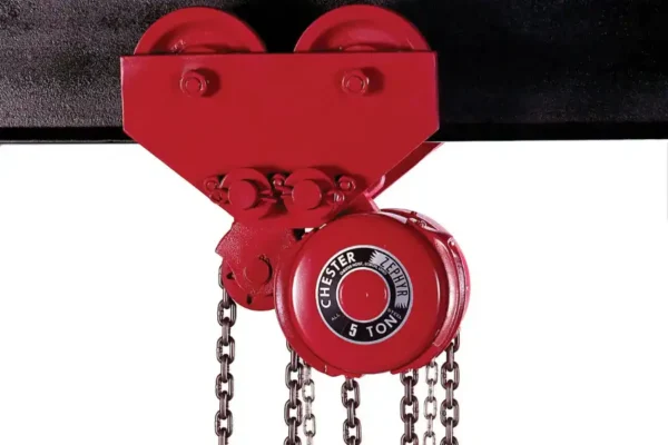 A red industrial chain hoist labeled “Chester Hoist 5 Ton” is mounted on a black beam, with chains hanging down.