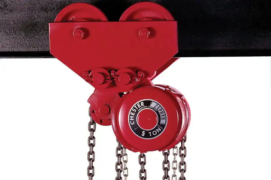 A red industrial chain hoist labeled “Chester Hoist 5 Ton” is mounted on a black beam, with chains hanging down.