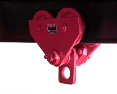 A red industrial trolley hoist is attached to a horizontal beam, designed for lifting or moving heavy loads.